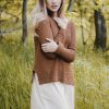 woman wearing brown sweater standing on green grass field