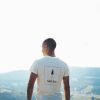 man in white crew neck t-shirt standing on top of mountain during daytime