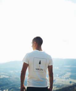 man in white crew neck t-shirt standing on top of mountain during daytime