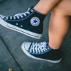 person wearing black Converse All-star sneakers