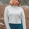 portrait photography of woman wearing white sweater and blue denim jeans