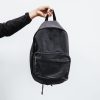 person in black jacket holding black backpack